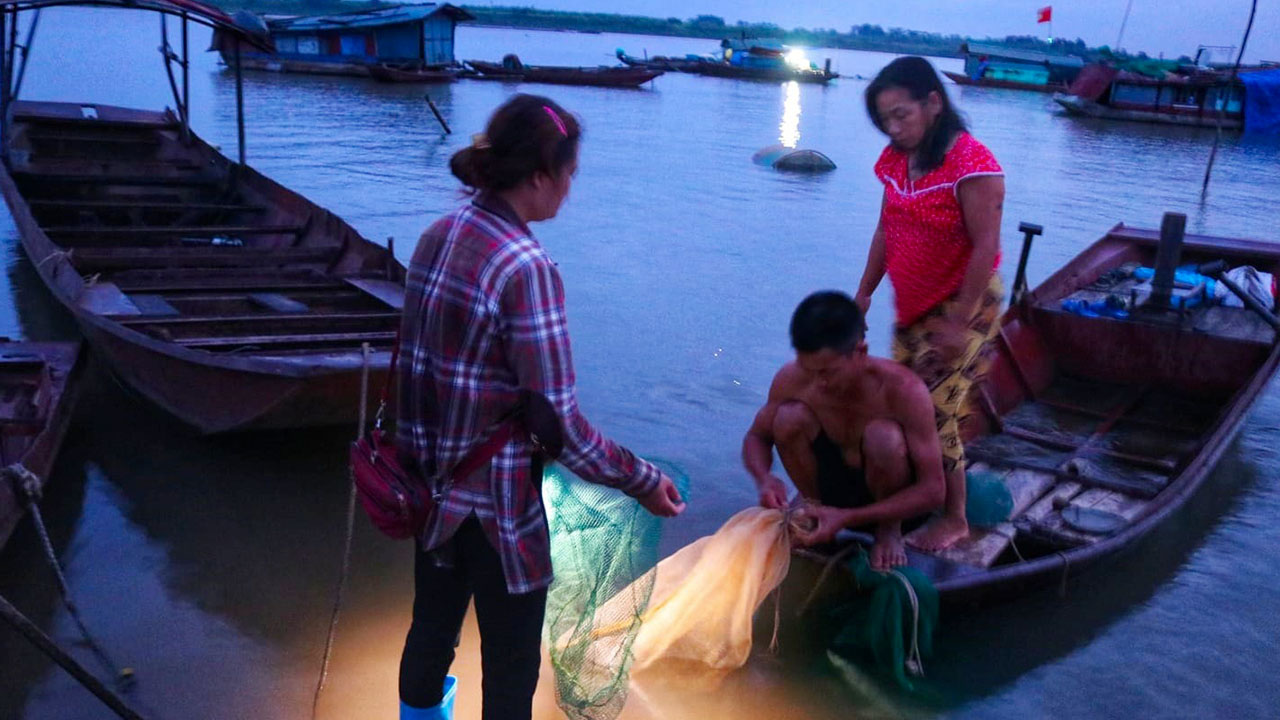 Fishermen make a living by fishing on the Red River