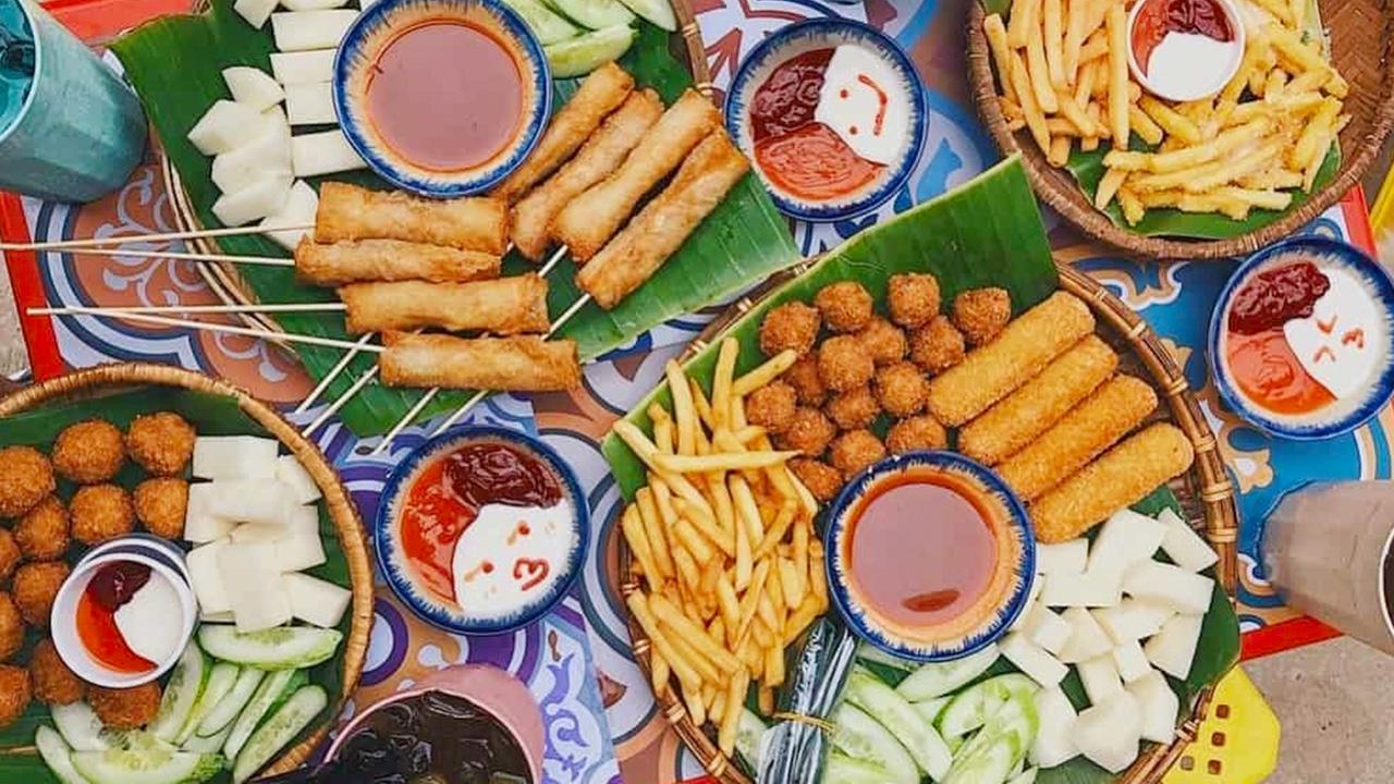 Grilled seafood, fried tofu, and spring rolls on a Hanoi street table