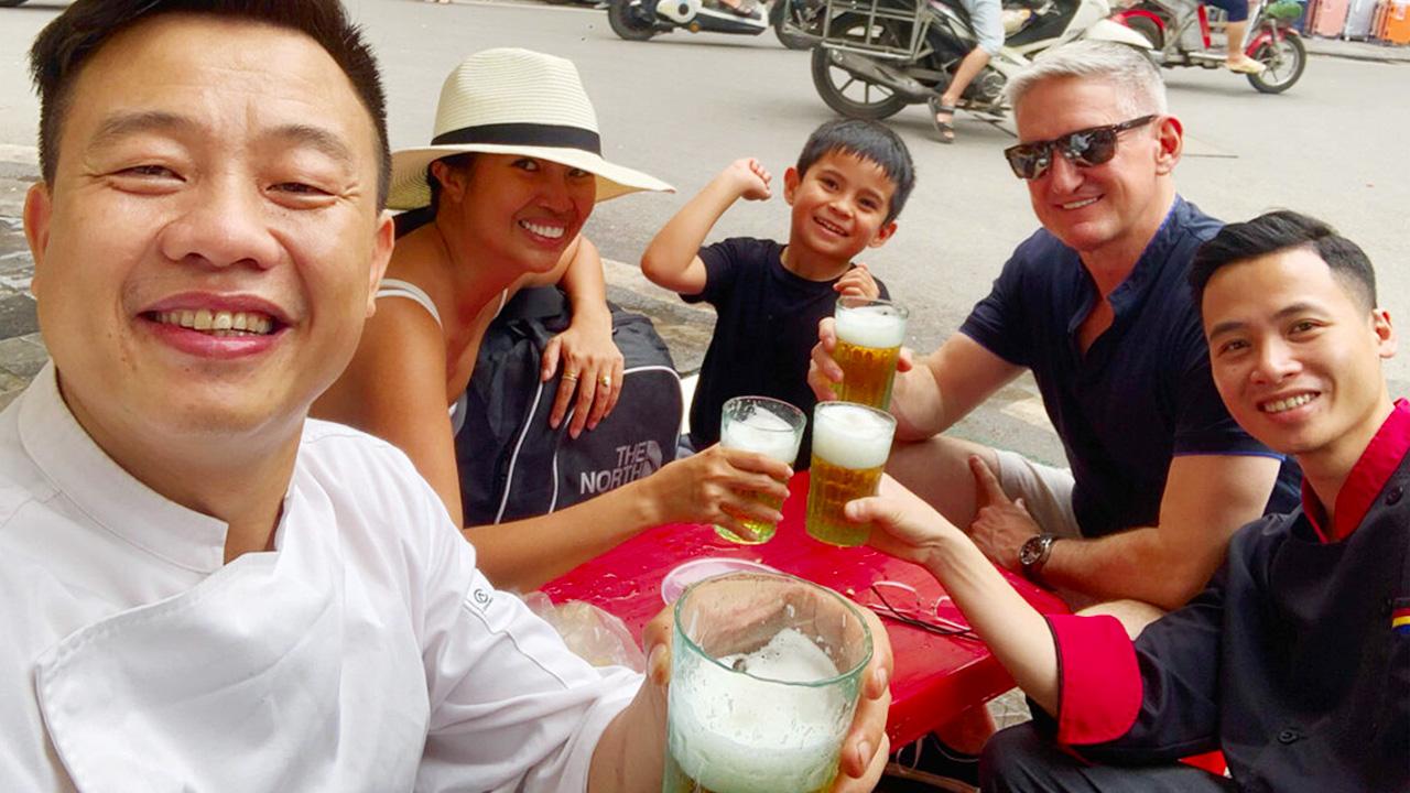 Small blue plastic stools and tables filled with beer glasses on Hanoi sidewalk