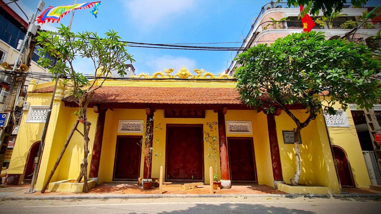 Cổng đền Bạch Mã cổ kính với cột đá và biển hiệu chữ Hán