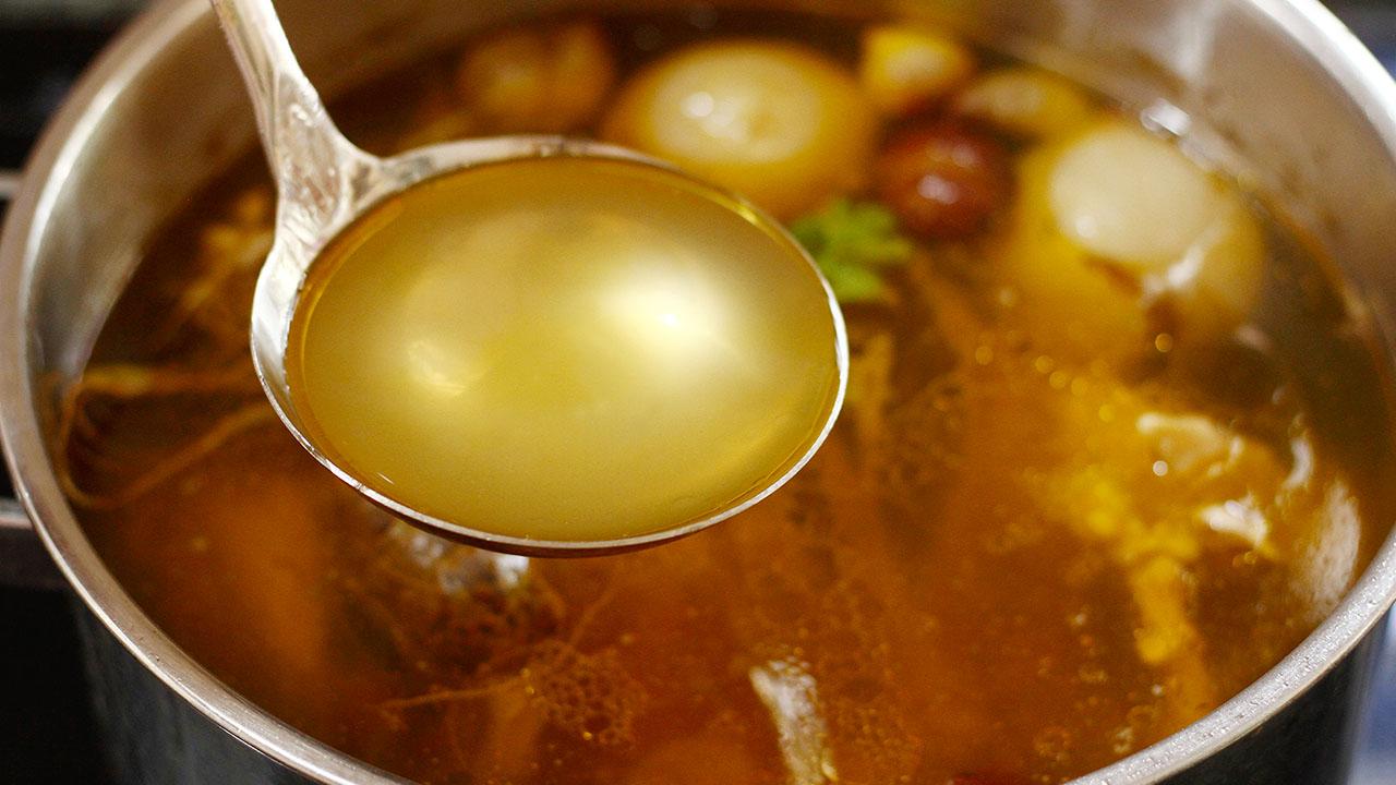 Nồi nước dùng phở Hà Nội đang sôi trên bếp than đỏ rực.